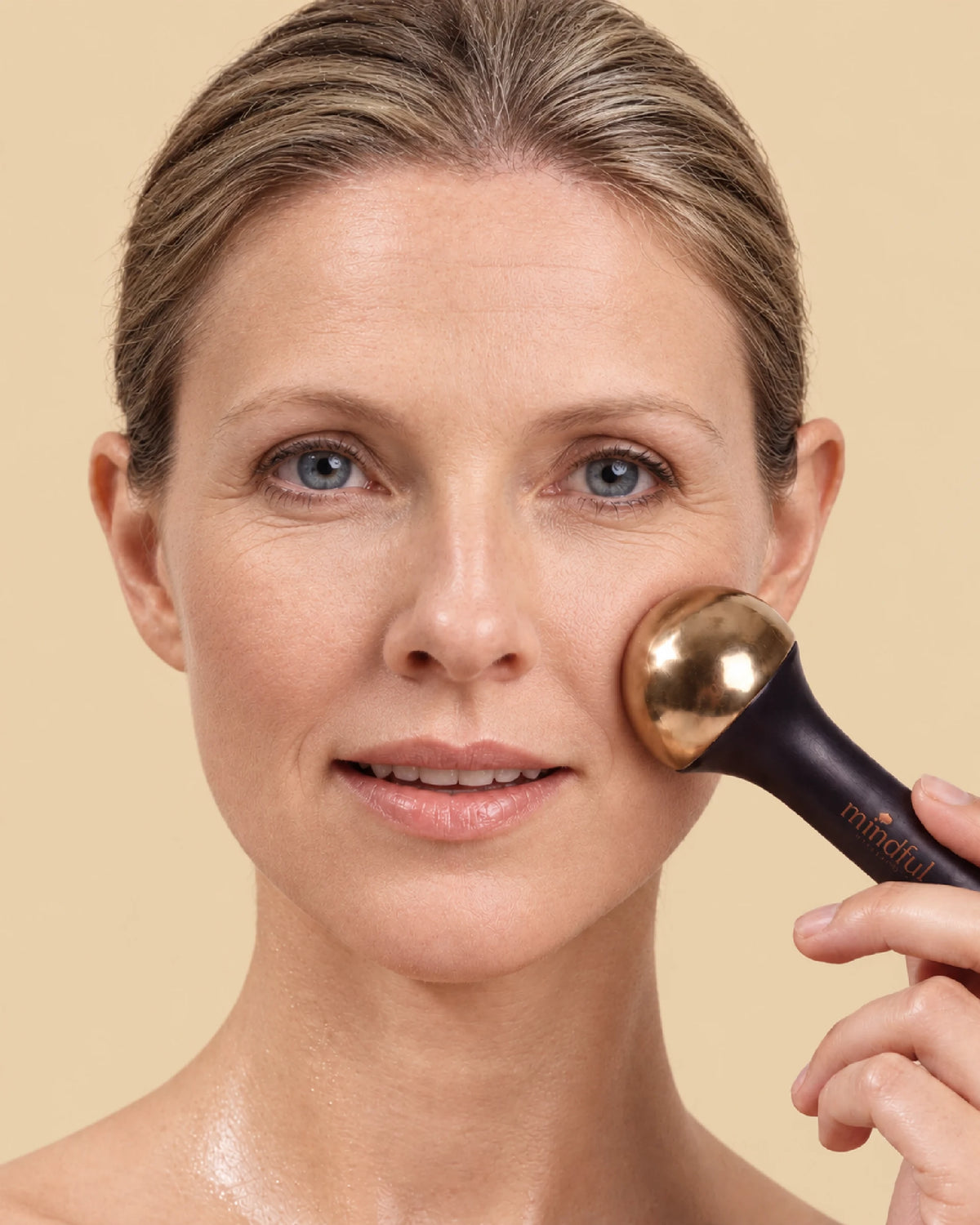 That yoga glow Kansa wand: model massaging her cheek with the wand